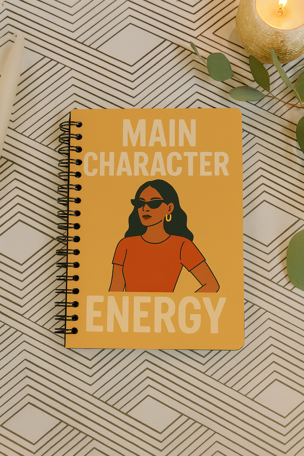 Cover of handmade spiral journal titled ‘Main Character Energy’ featuring an illustrated woman in sunglasses on a mustard yellow background.