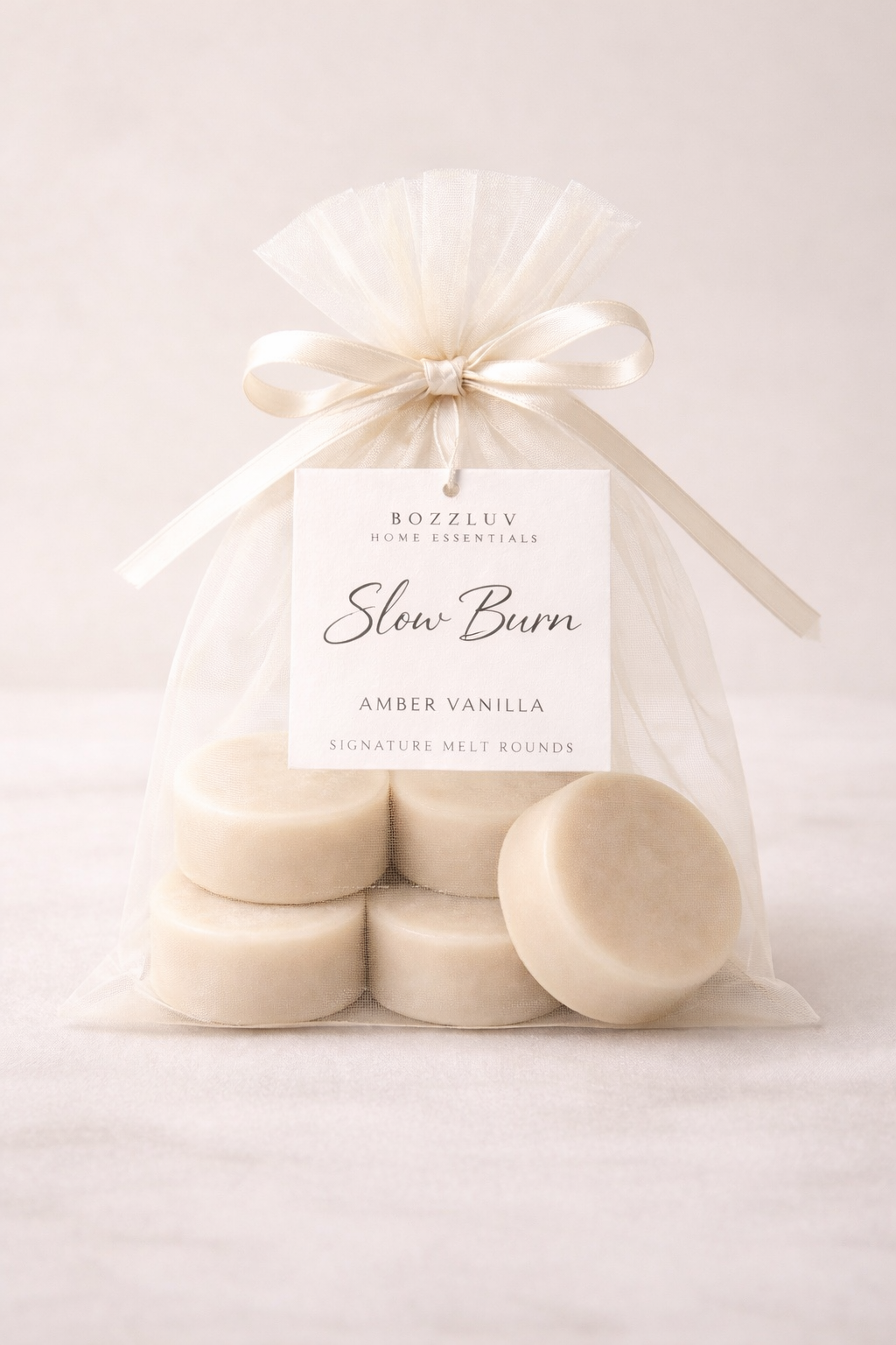 BozzLuv Home Essentials Slow Burn amber vanilla signature melt rounds in ivory organza bag with minimalist tag.