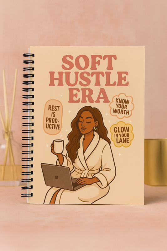 Cover of handmade spiral journal titled ‘Soft Hustle Era’ featuring a woman in a robe with coffee and laptop.