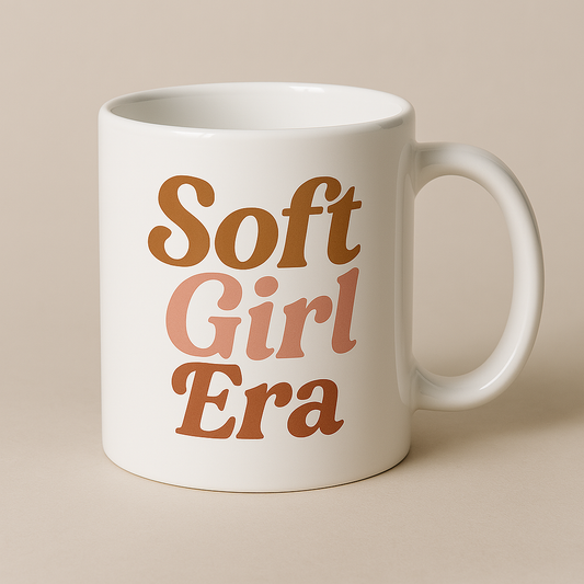 White 15oz ceramic coffee mug featuring retro “Soft Girl Era” text in warm neutral tones, aesthetic girl boss drinkware by BozzLuv Essentials.